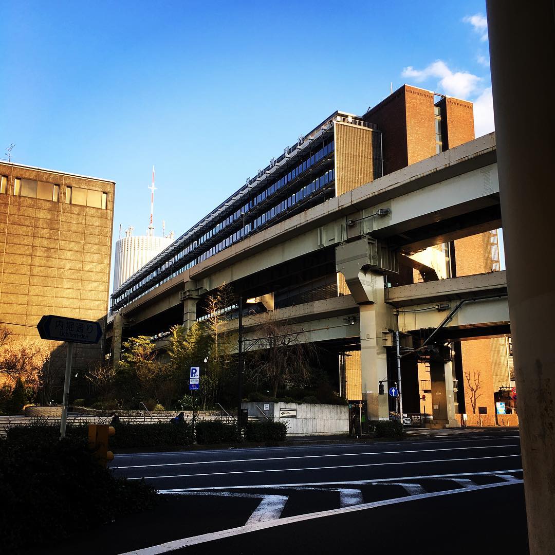 冬日斜陽照亮高架橋旁的磚樓與窗戶